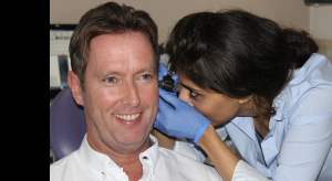 An audiologist checking if the patient needs 2 hearing aids