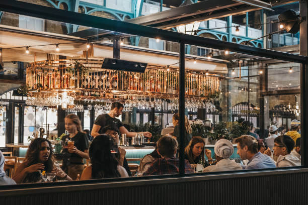 A busy bar scene through the window from the outside.