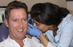 An audiologist checking if the patient needs 2 hearing aids